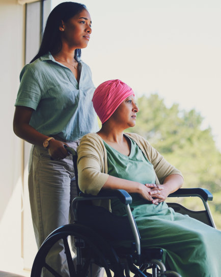 woman standing and senior sitting in wheelchair