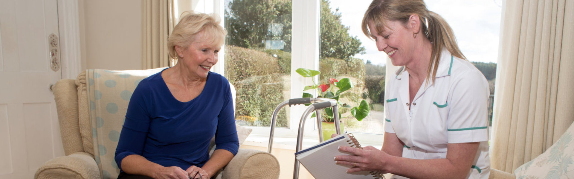 woman and senior looking in notebook